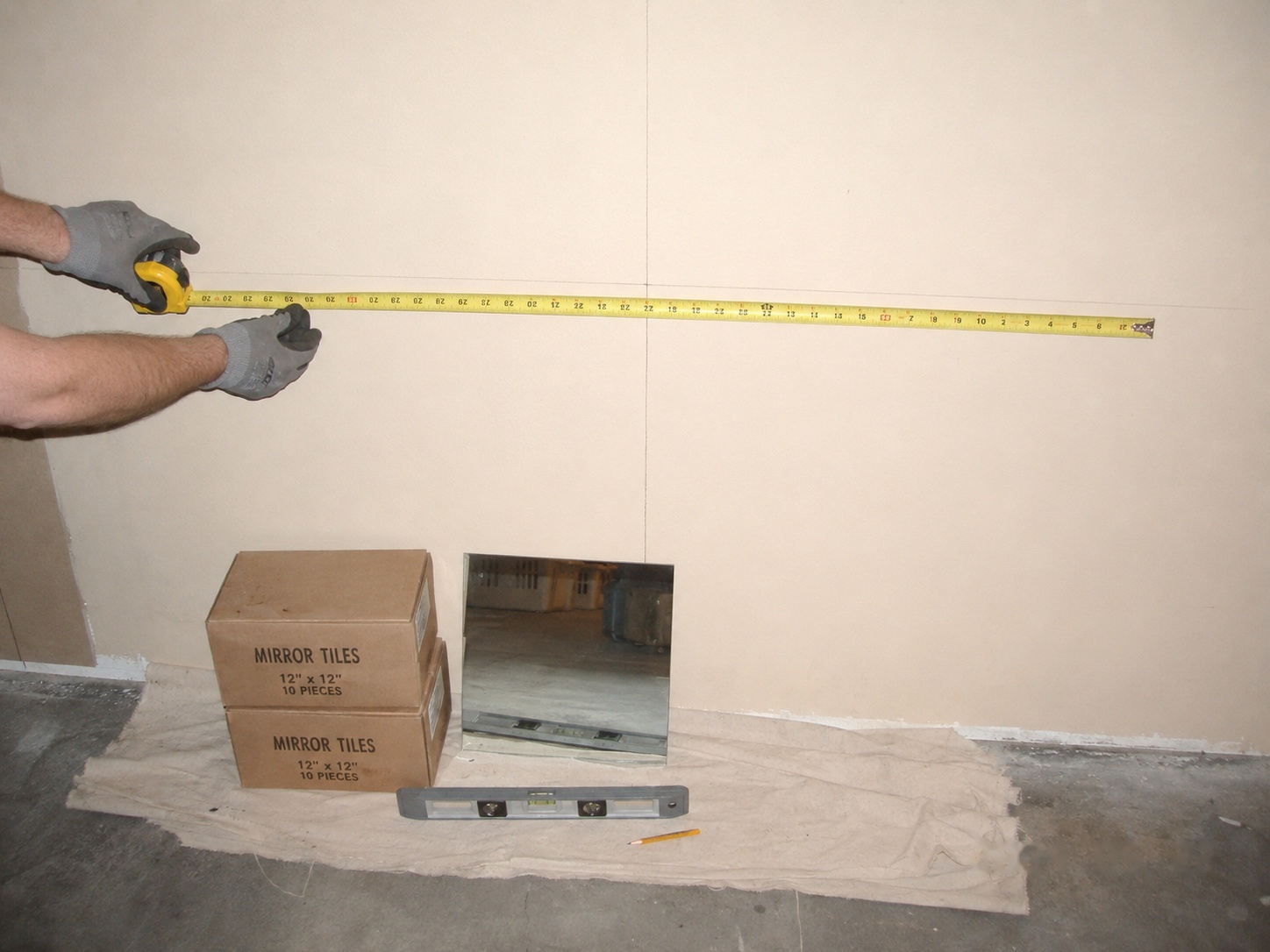 Measure the wall, mark the center point, and sanity-check the tile count before opening a single box.